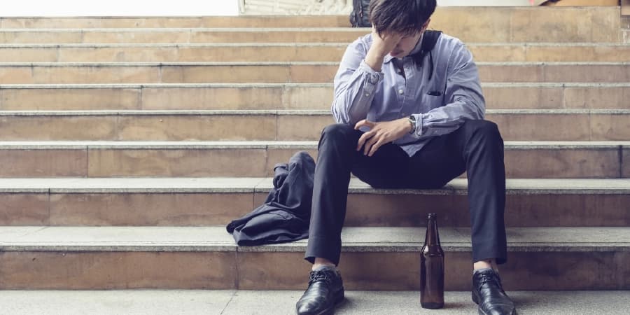 5 Stress Management Tips from AA to Stay Sober A man regretting drinking