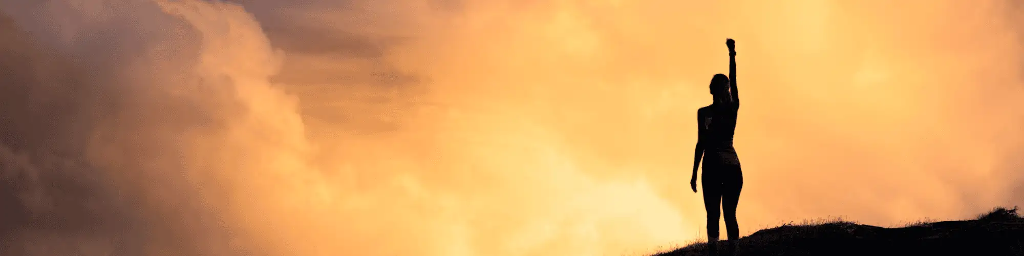 Staying Strong During Early Sobriety with AA Meetings Houston A person's silhouette with their fist up, symbolizing strength