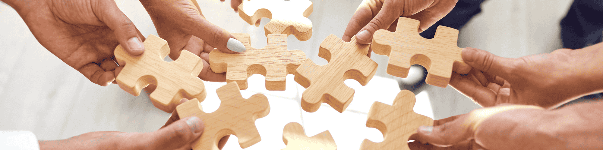 building puzzle each person holding a piece of puzzle