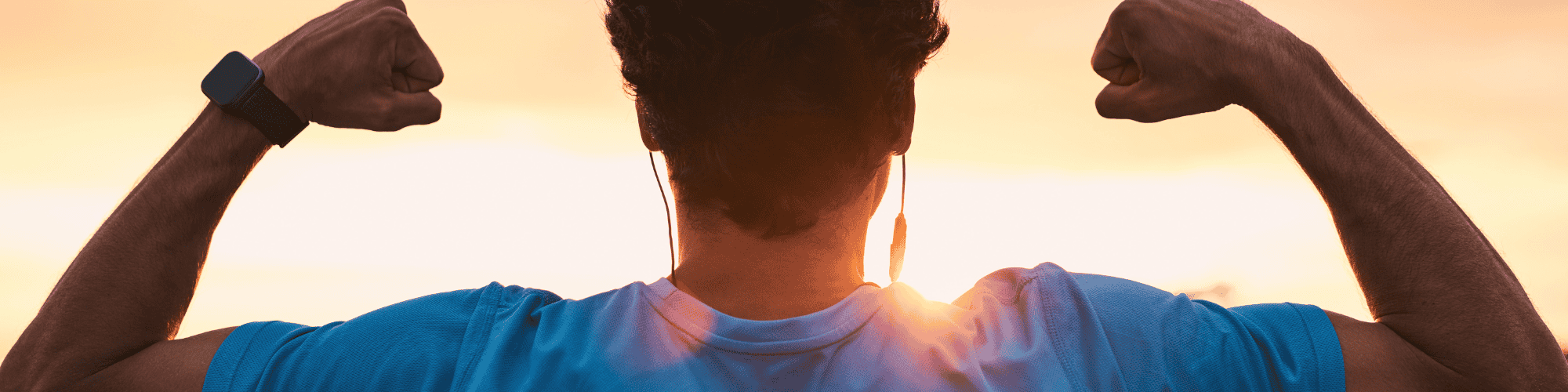 empowered man man in biceps curled up facing the sunset